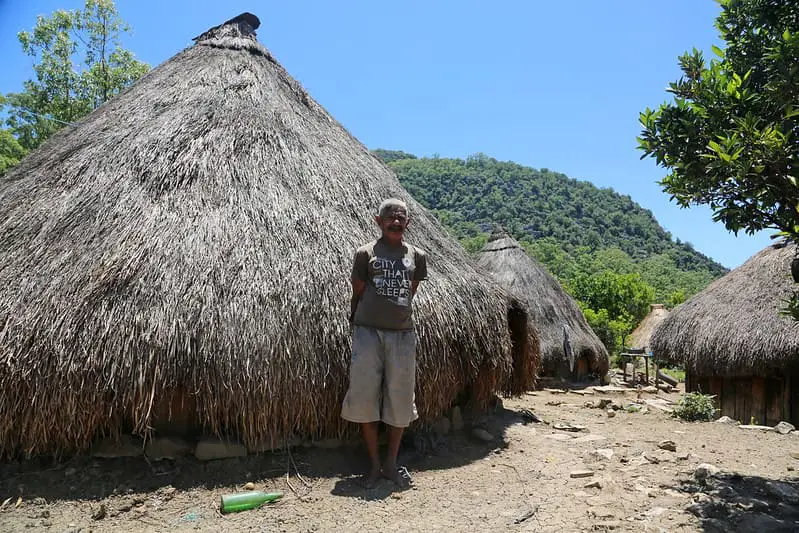 A local man standing in front of a traditional house in Oecussi