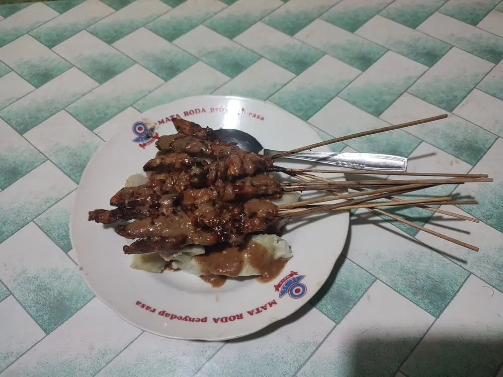Sate Ayam - skewers of chicken meat coated with peanut sauce and served over rice.