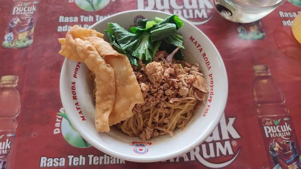 Yammie - a bowl of thin noodles with krupuk, greens and minced meat.