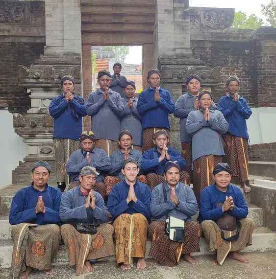 A group of people dressed in Javanese clothes posing for a picture in front of the tomb of Sultan Agung
