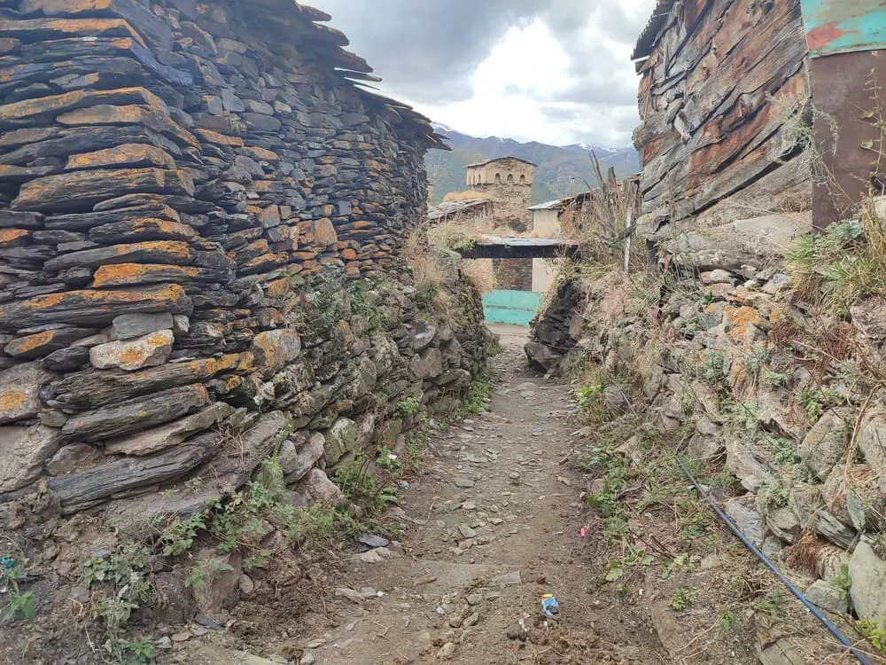 Inside Ushguli on a narrow alley with stone houses