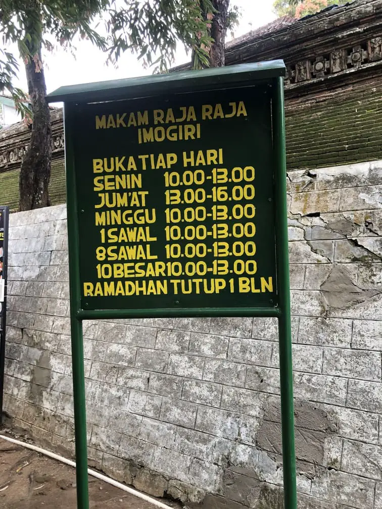 Infotable with opening times of the Imogiri Royal Cemetery on site.