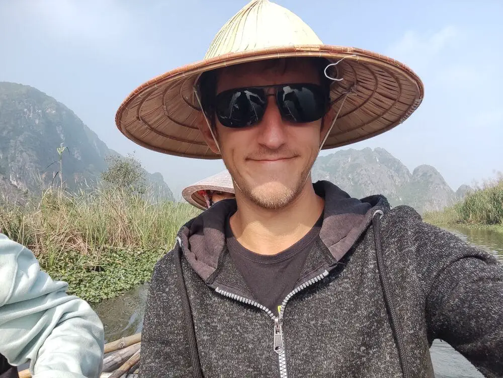 Simon wearing a Vietnamese hat on the boat in Van Long