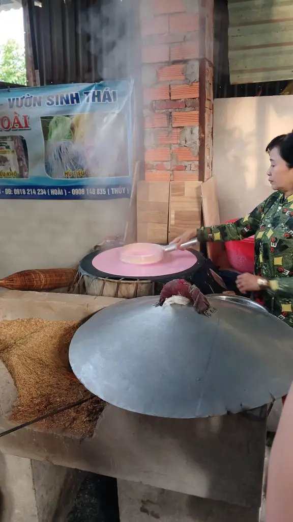 A Vietnamese lady preparing a rice base for noodles