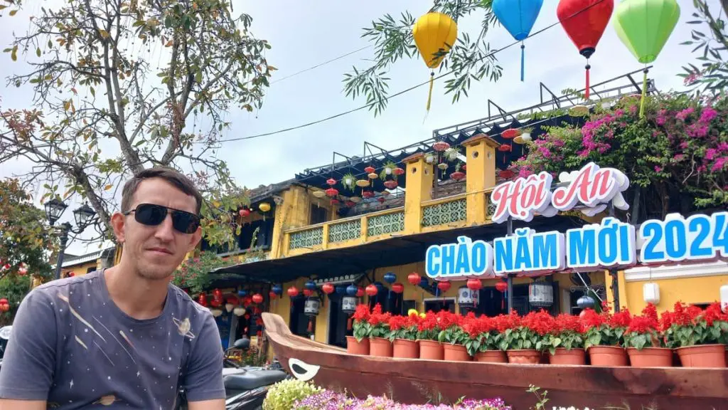 Simon in Hoi An in front of a sign for Tet, the Vietnamese new year