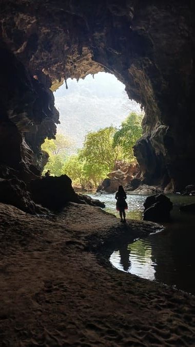 a woman standing in a cave