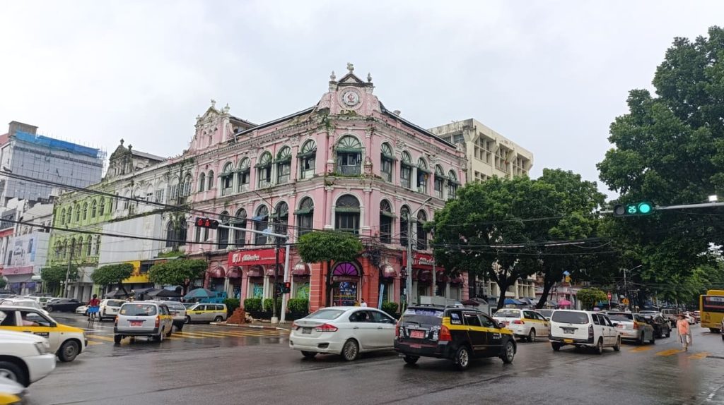 A busy street and a colonial building in Yangon