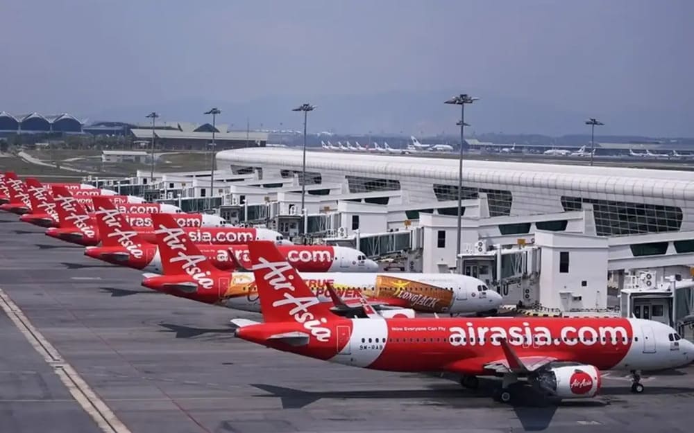 a fleet of air asia planes docked at an airport