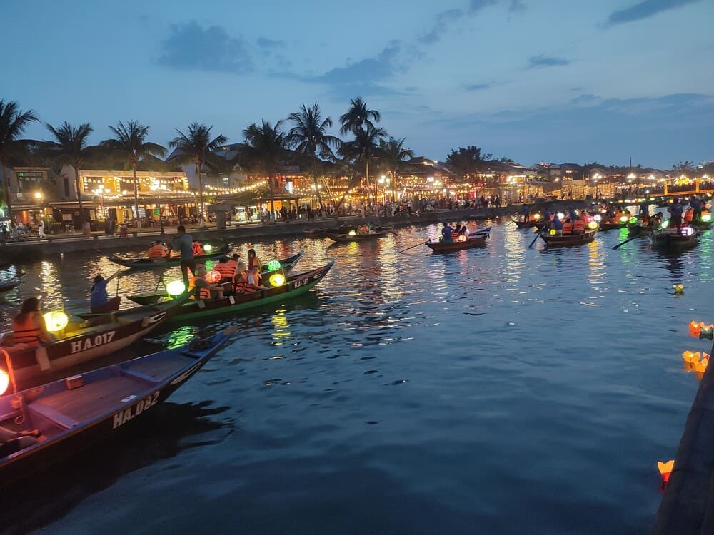 boats with tourists floating on the river in Hoi An with lanterns lighted up