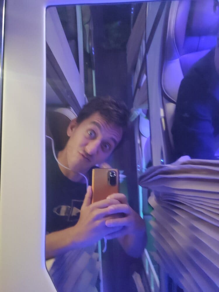 Simon taking a mirror selfie inside a bus