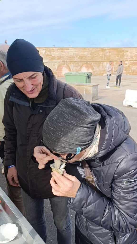 A woman eating an oyster and a man watching her