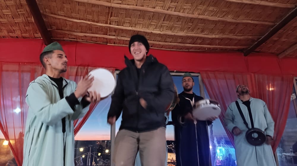 Simon dancing with Berber musicians in a desert camp.