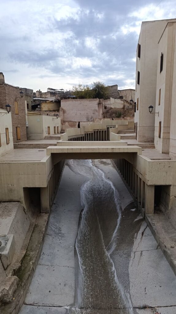 A river passing under a small bridge