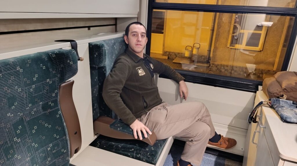 Simon sitting inside a couchette on the sofia to istanbul train