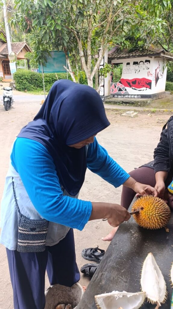 Ibu cutting a durian open in Indonesia