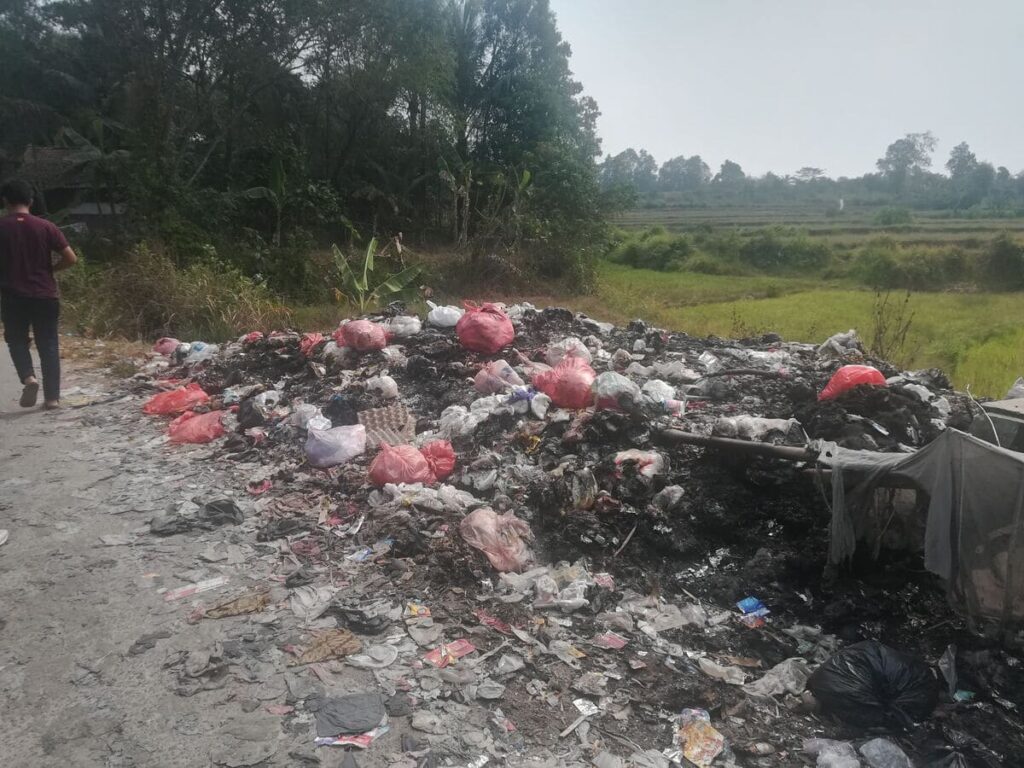 A half-burned roadside trash pile in suburban Jakarta.