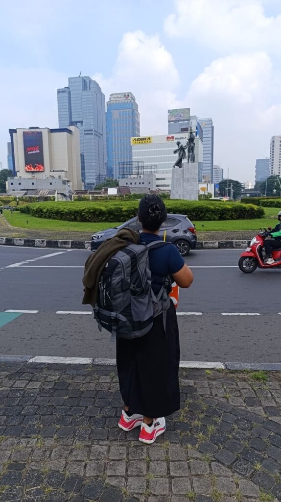 Yulli facing a monument in Jakarta